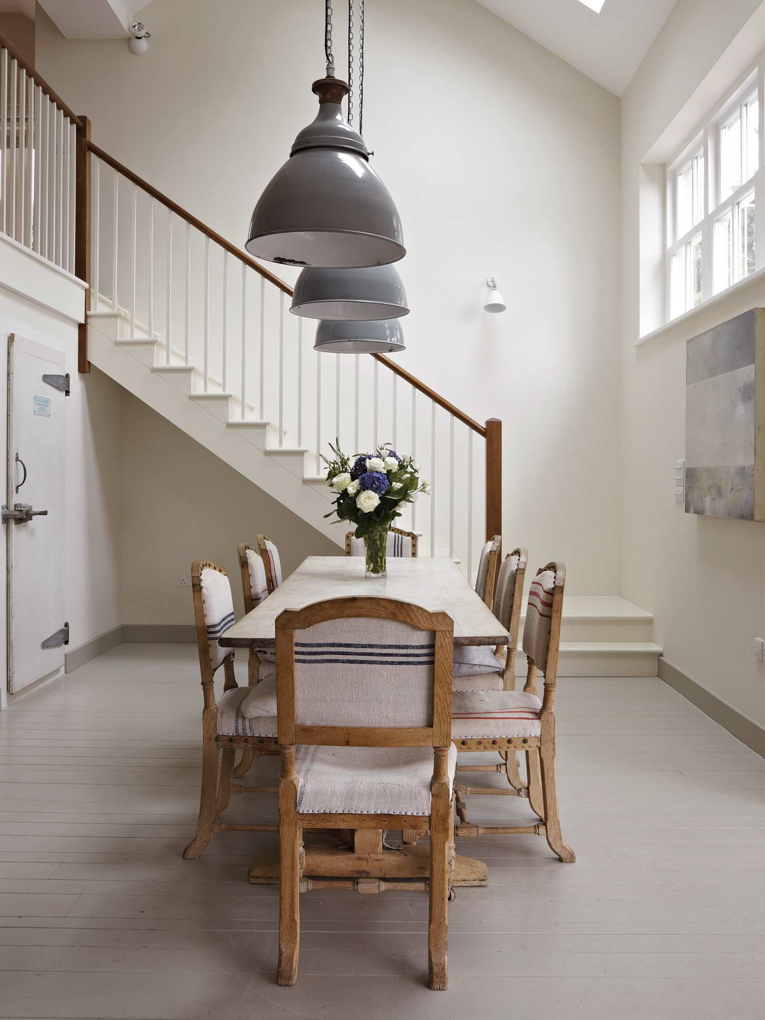 Esszimmer mit Slipper Satin No. 2004 von Farrow und Ball. Warmes Off-White an Wänden und Boden in einem großen hellen Raum mit natürlichen Materialien.