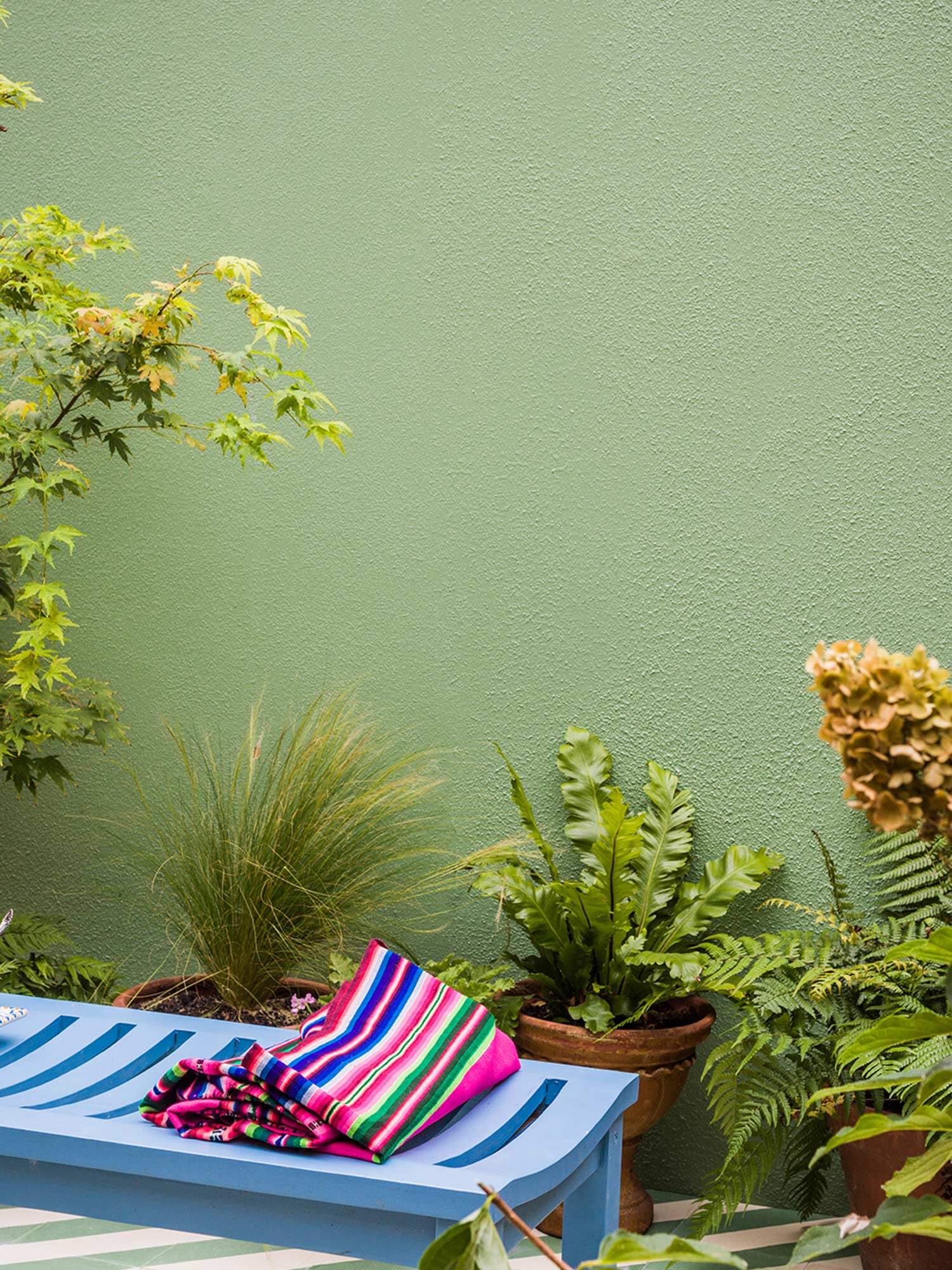Terrasse mit Breakfast Room Green No. 81 an der Außenwand und Cook's Blue No. 237 auf der Gartenliege von Farrow & Ball.