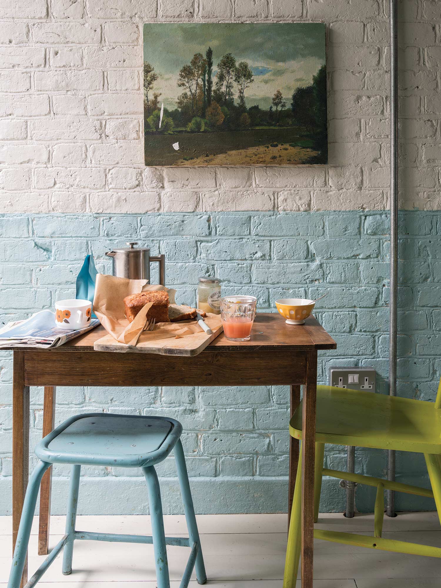 Esszimmer mit Ammonite No. 274 oben und Dix Blue No. 82 unten von Farrow & Ball. Zwei Farbtöne auf einer Backsteinwand.