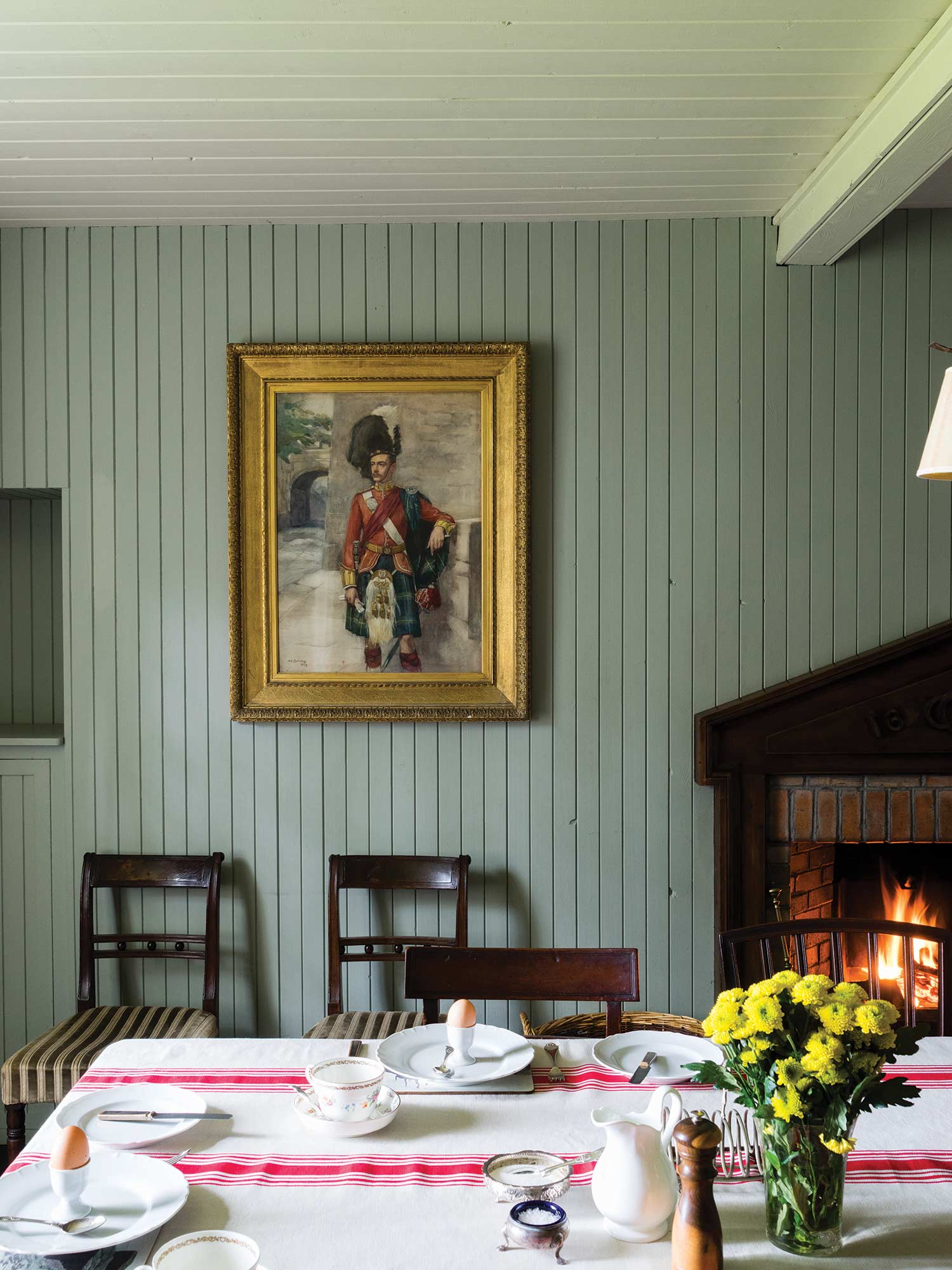 Esszimmer mit Blue Gray No. 91 auf der Holzvertäfelung und Off-White No. 3 an der Decke von Farrow & Ball. Traditioneller Raum mit offenem Kamin.