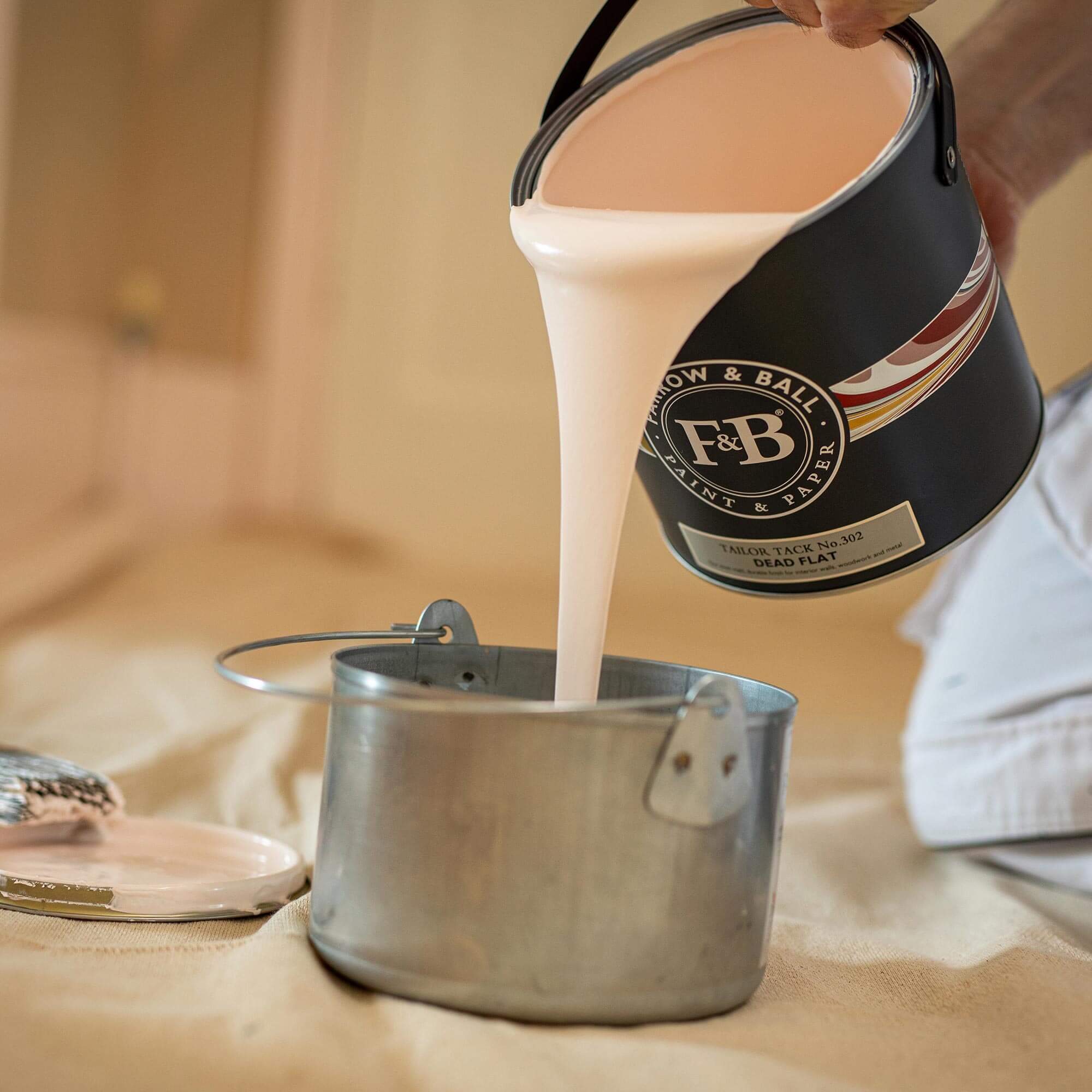 farrow & ball tailor tack 302 wird aus einem farbeimer gegossen